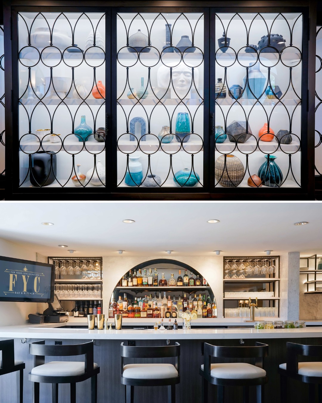 A modern bar with a display of assorted vases and glassware on upper shelves, and a counter below with bar stools, bottles, and a mounted screen.